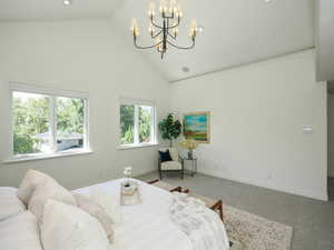 Carpeted bedroom with multiple windows, a high ceiling, and lofted ceiling