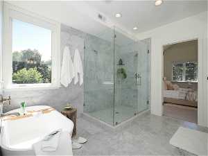 Bathroom with independent shower and bath, tile walls, a wealth of natural light, and light tile floors
