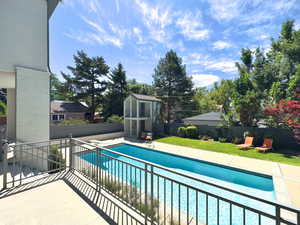 View of pool with a patio and an outdoor structure