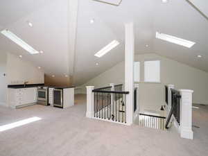 Bonus room with light carpet and vaulted ceiling with skylight