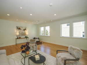 Hardwood floored living room featuring ornamental molding