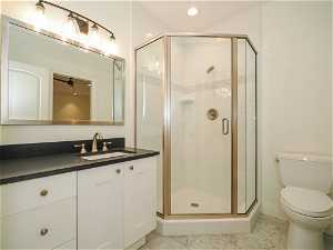 Bathroom with light tile floors, vanity, a shower with shower door, and mirror