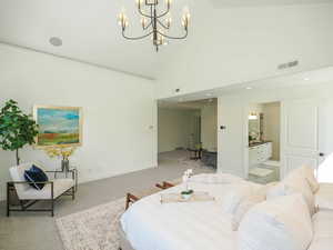 Bedroom with a high ceiling, lofted ceiling, and light carpet