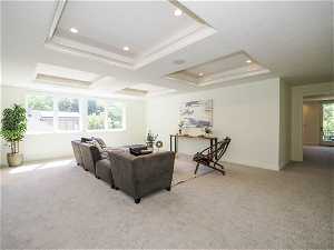 Living room with light carpet, a tray ceiling, and a wealth of natural light