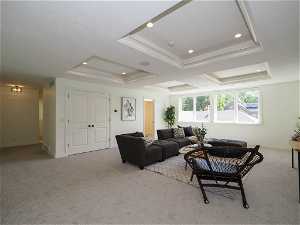 Carpeted living room featuring a raised ceiling
