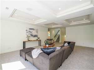 Living room with a tray ceiling and light carpet