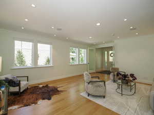 Hardwood floored living room featuring ornamental molding