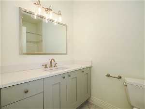 Bathroom with light tile floors, vanity, and mirror