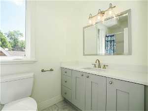 Bathroom with vanity, light tile flooring, and mirror