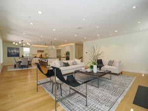 Living room with ornamental molding and light hardwood flooring