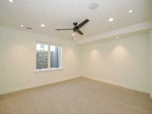 Spare room featuring light carpet and ceiling fan