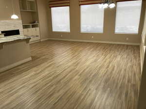 Kitchen featuring light parquet floors, decorative light fixtures, and a healthy amount of sunlight