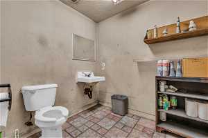 Half bath with tile floors, mirror, sink, and toilet