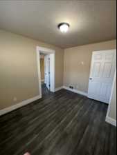 Empty room with vinyl floors, a textured ceiling, and a wealth of natural light (other side view)