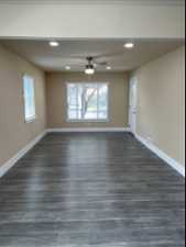 Wood floored spare room with plenty of natural light and ceiling fan