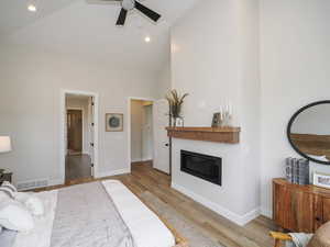 Bedroom featuring a high ceiling, lofted ceiling, ceiling fan, and light tile floors