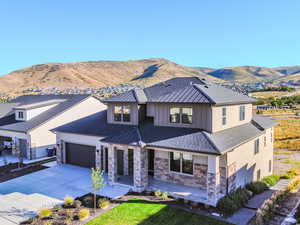 View of front facade featuring a mountain view, a garage, and a front lawn