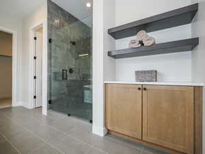 Bathroom with an enclosed shower and light tile floors