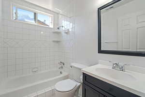 Full bathroom with tiled shower / bath, toilet, and vanity