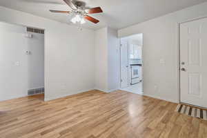 Empty room with light hardwood / wood-style flooring and ceiling fan