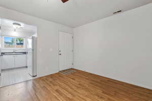 Interior space with ceiling fan, sink, and light hardwood / wood-style floors