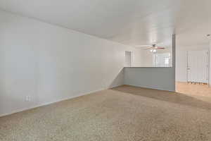 Unfurnished room with light colored carpet and ceiling fan