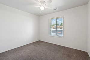 Carpeted spare room featuring ceiling fan