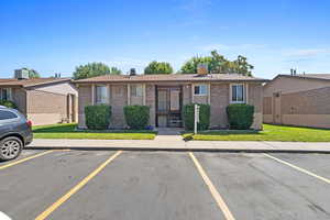 View of front of home with a front yard and central AC unit