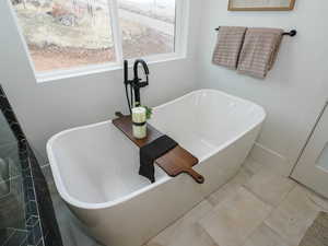 Bathroom with a tub and tile floors