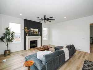 Living room with light hardwood / wood-style floors and ceiling fan