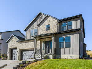 View of front of house with a front lawn, central air condition unit, and a garage