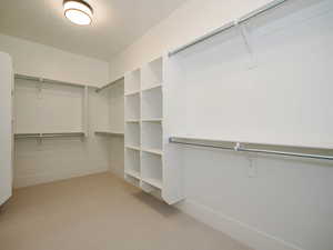 Walk in closet with light carpet