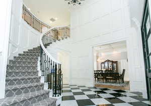 Immaculate foyer with a wainscoting spiral staircase and exquisite marble floors.