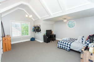 Bedroom with lofted ceiling with beams.