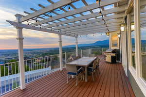 Deck at dusk featuring a pergola on the wrap around deck.