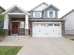 Craftsman-style home with garage and a front lawn