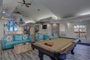 Playroom with lofted ceiling, a high ceiling, light hardwood flooring, and ceiling fan