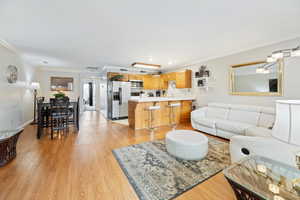 Living room with ornamental molding and light hardwood floors