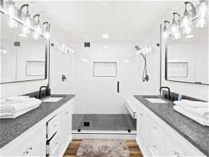 Upstairs Master Bathroom with double vanity, a shower with shower door, mirror, and hardwood flooring
