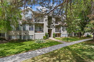View of front of property with balcony and a front lawn