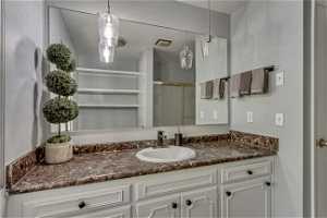 Bathroom featuring vanity with extensive cabinet space and mirror