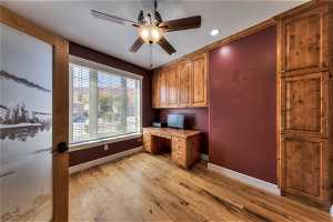 Office area with ceiling fan and light hardwood flooring