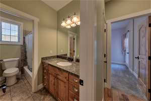 Full bathroom featuring tile floors, shower / tub combo with curtain, vanity, and mirror