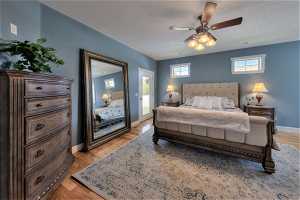 Bedroom with multiple windows, hardwood flooring, and ceiling fan