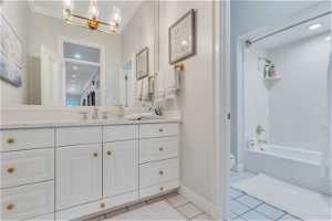 Bathroom with  shower combination, vanity, mirror, and light tile floors
