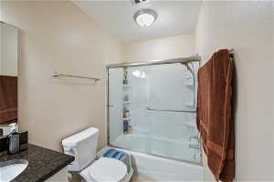 Full bathroom with combined bath / shower with glass door and vanity