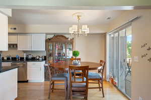 Dining area with a chandelier and light hardwood floors