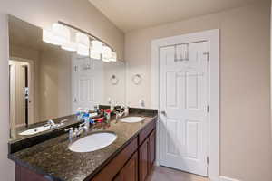 Bathroom with mirror and dual bowl vanity