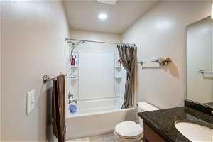 Full bathroom with large vanity, mirror, and shower / bathtub combination with curtain