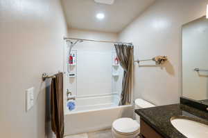 Full bathroom with large vanity, mirror, and shower / bathtub combination with curtain